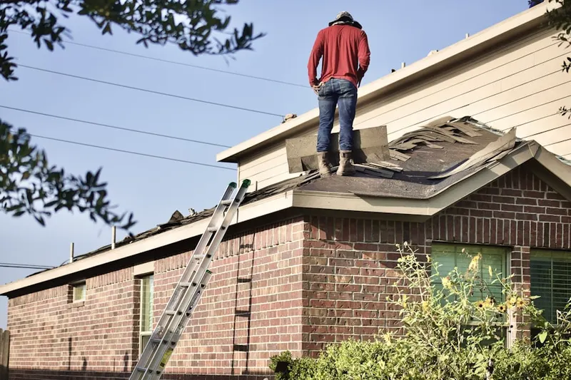 Professional roofer working on a residential roof in The Hamlet